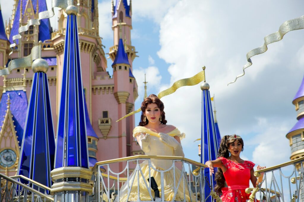 Princess blowing a kiss from a parade float in front of Cinderella Castle at Walt Disney World